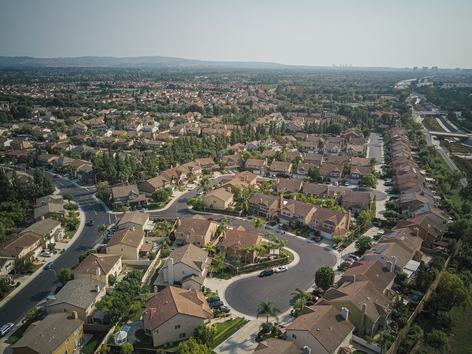 Vista aérea de um bairro residencial com casas, ruas e áreas verdes